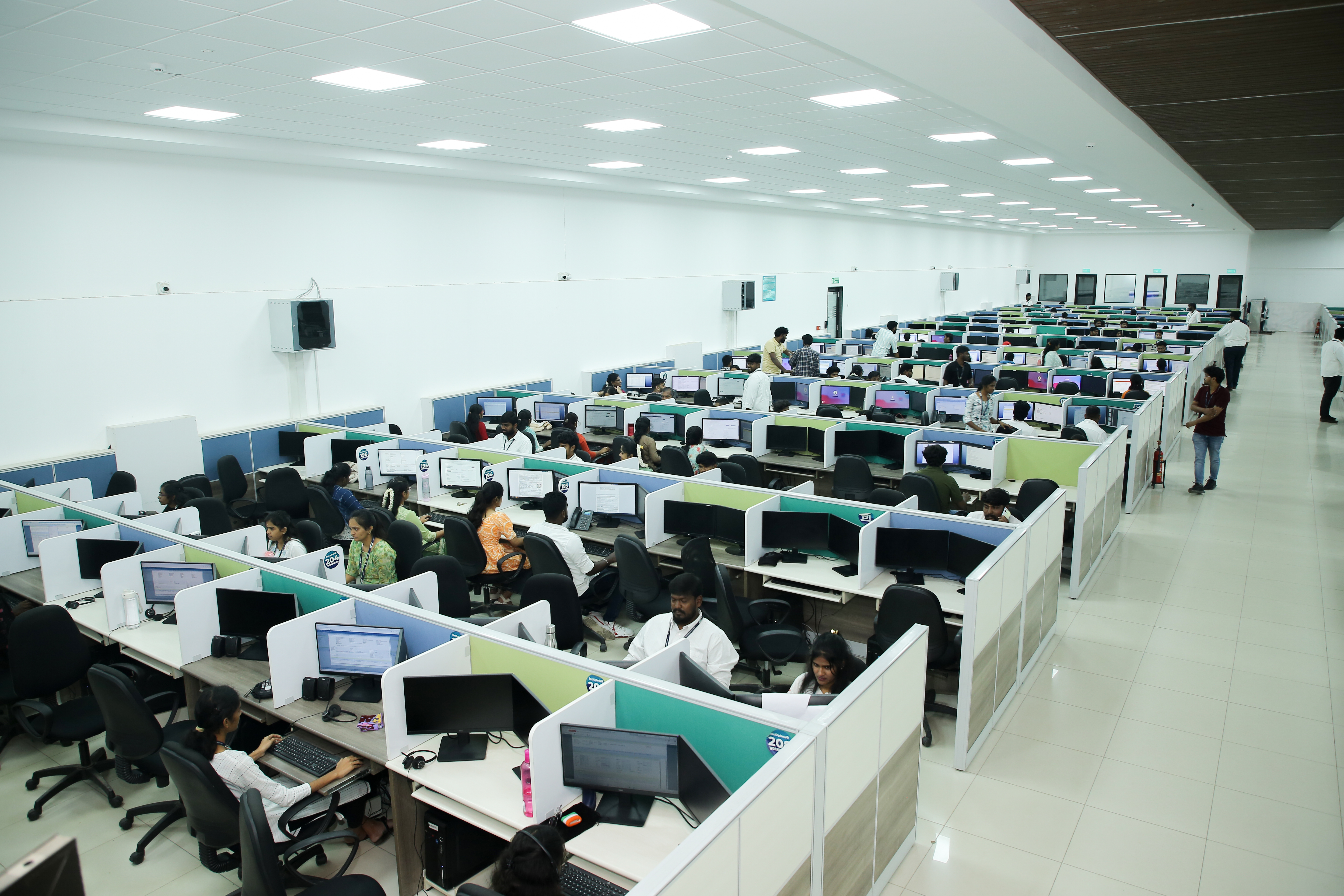 Large, modern office floor with many workstations.